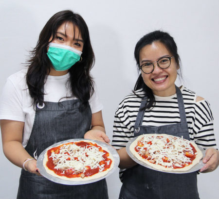 Two students making pizza
