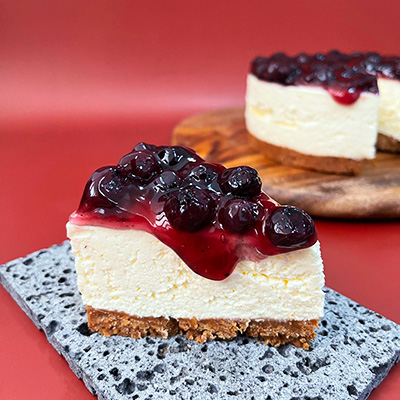 A slice of New-York cheesecake topped with blueberries