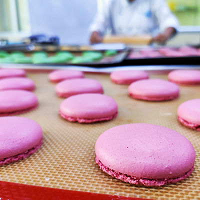 Pink macaron shells on a silicon mat