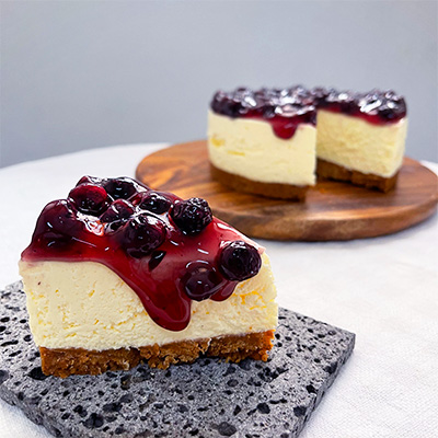 A slice of cheesecake topped with blueberries